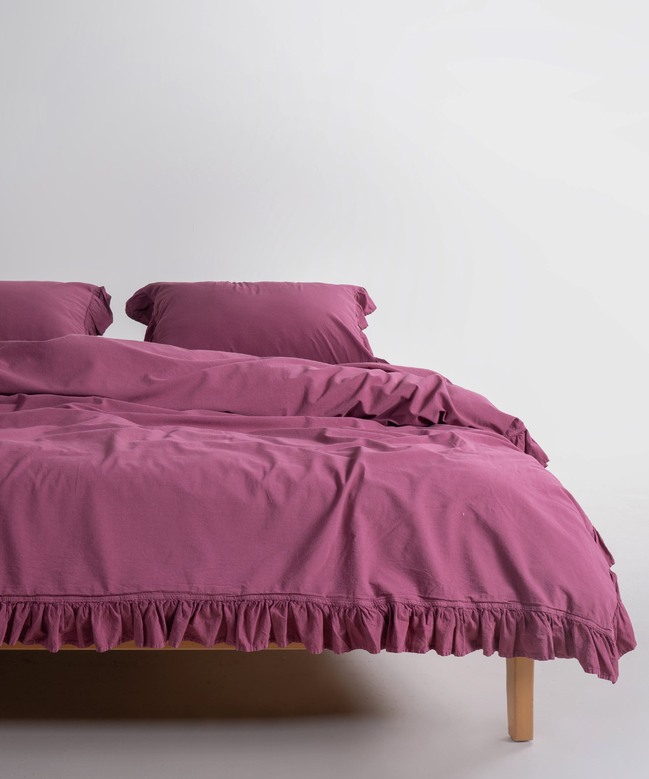 Stonewash Exclusive 100% soft cotton duvet cover set in Raspberry with elegant ruffle detailing, breathable luxury bedding available in UK and US sizes.