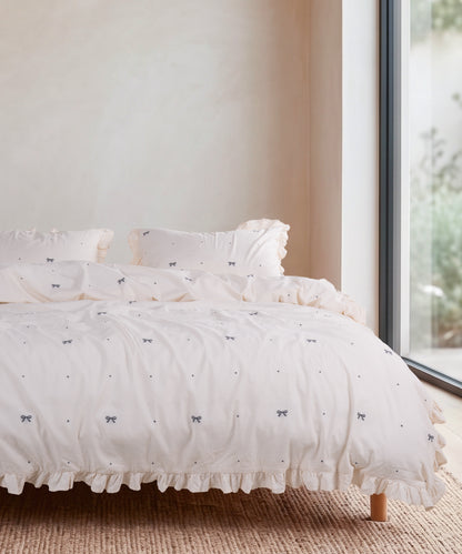 Cream 100% cotton duvet cover set with ribbon pattern styled on a bed – Limasso London