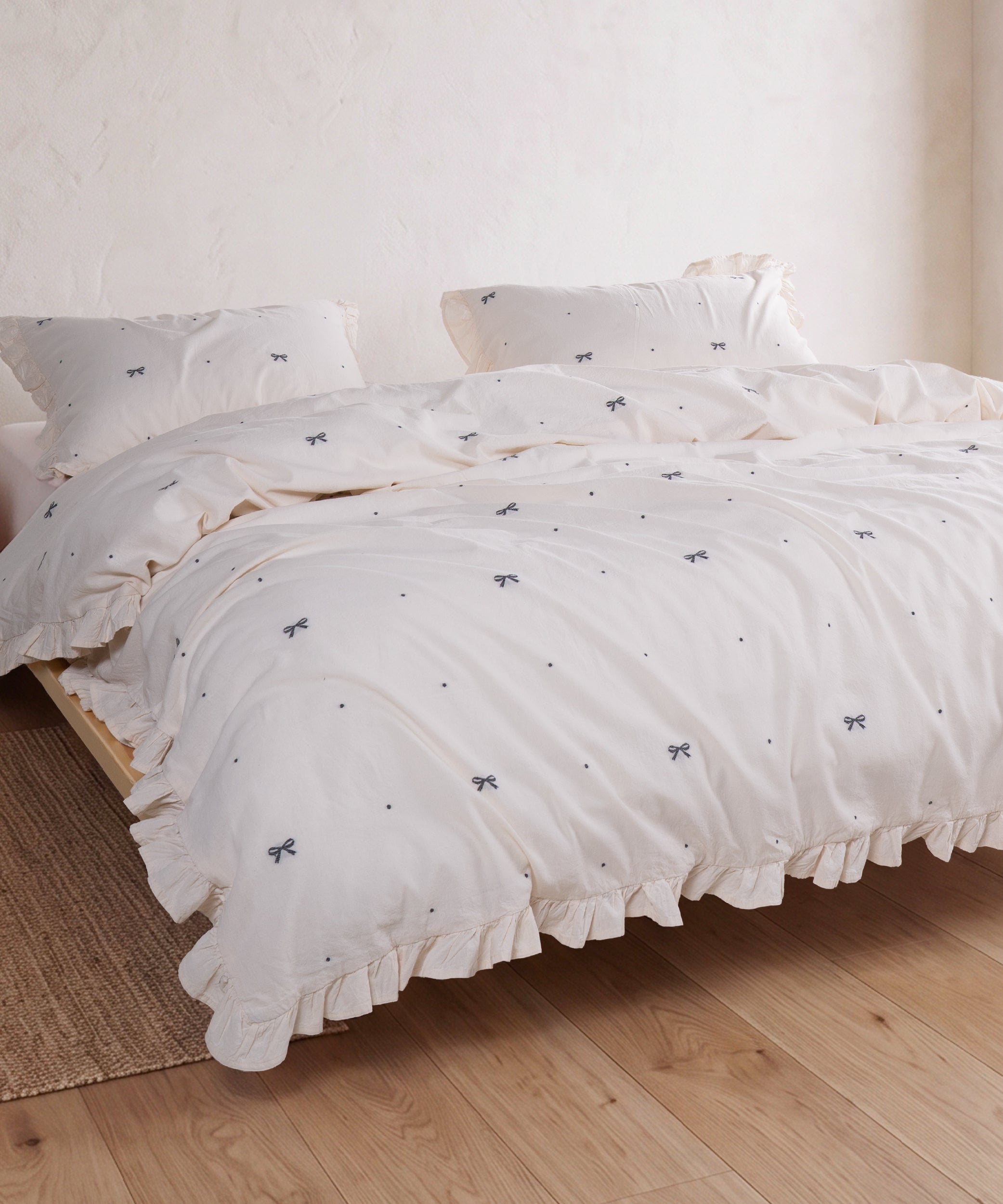Cream cotton duvet cover set with jacquard ribbon detail styled in a serene bedroom – Limasso London