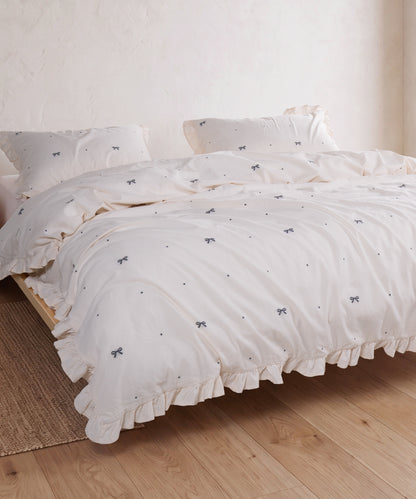 Cream cotton duvet cover set with jacquard ribbon detail styled in a serene bedroom – Limasso London