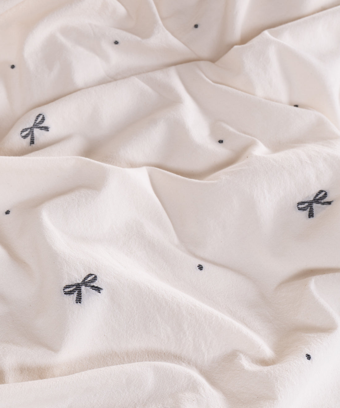 Close-up of garment washed cream cotton fabric with woven jacquard ribbon texture – Limasso London