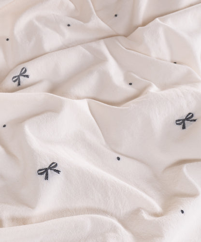 Close-up of garment washed cream cotton fabric with woven jacquard ribbon texture – Limasso London