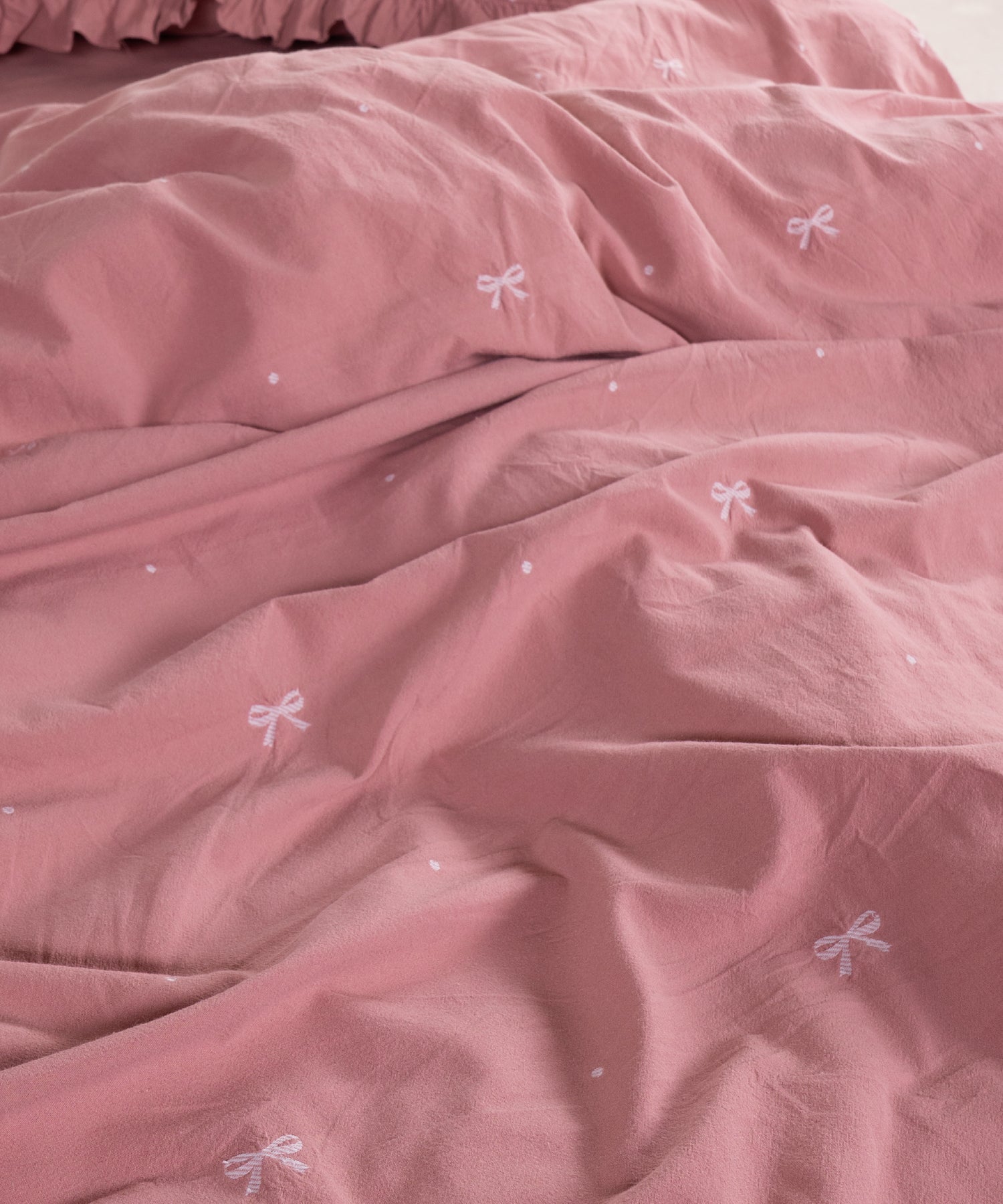 Close-up of stonewashed old rose cotton fabric with woven jacquard ribbon texture – Limasso London