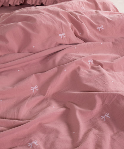 Close-up of stonewashed old rose cotton fabric with woven jacquard ribbon texture – Limasso London