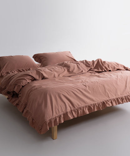 Close-up of ruffled edge detail on stonewashed cotton duvet cover set, soft textured breathable fabric for luxury UK interiors