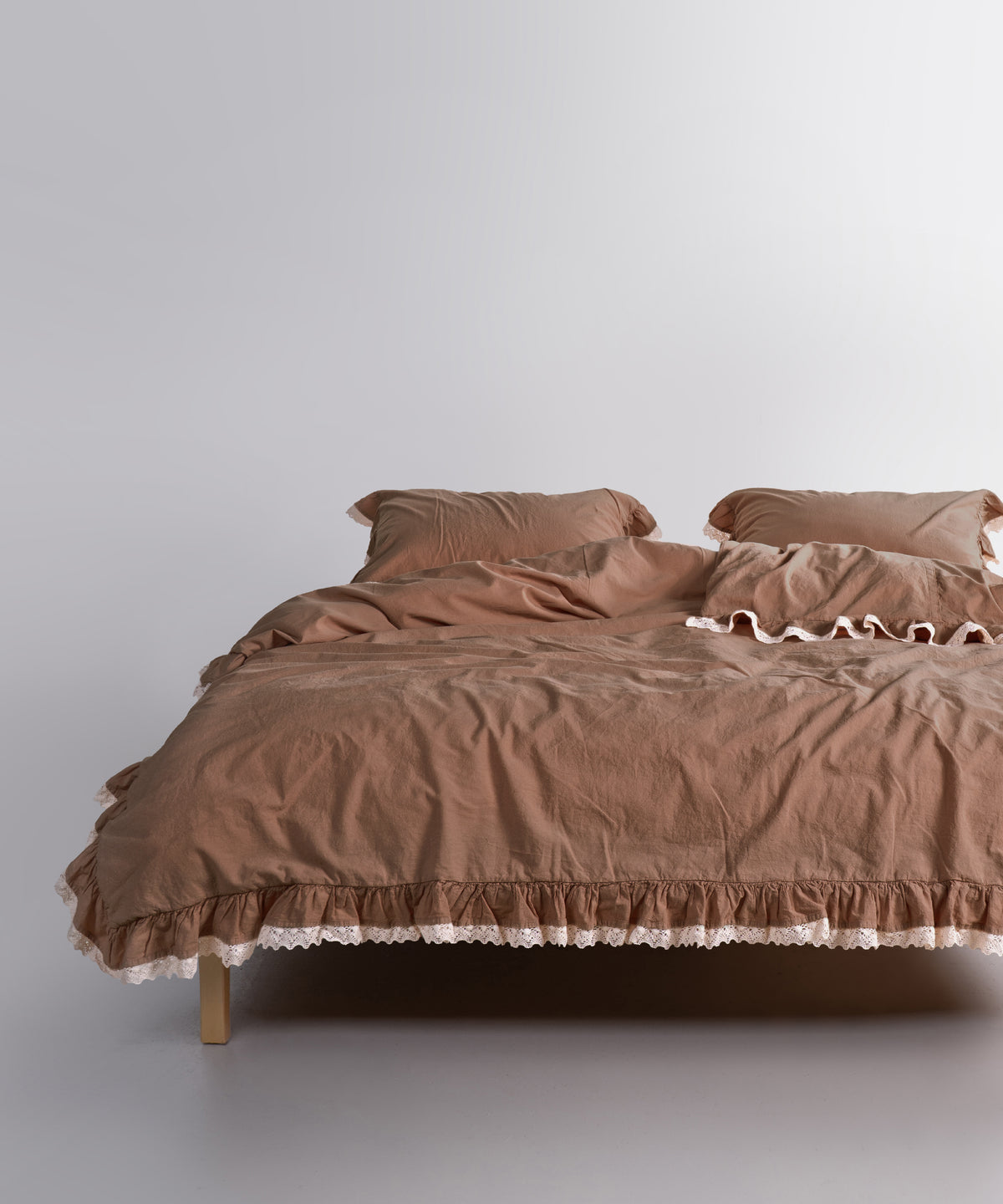 Close-up of ruffle and guipure lace edging on brown stonewashed cotton duvet cover set