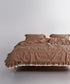 Close-up of ruffle and guipure lace edging on brown stonewashed cotton duvet cover set
