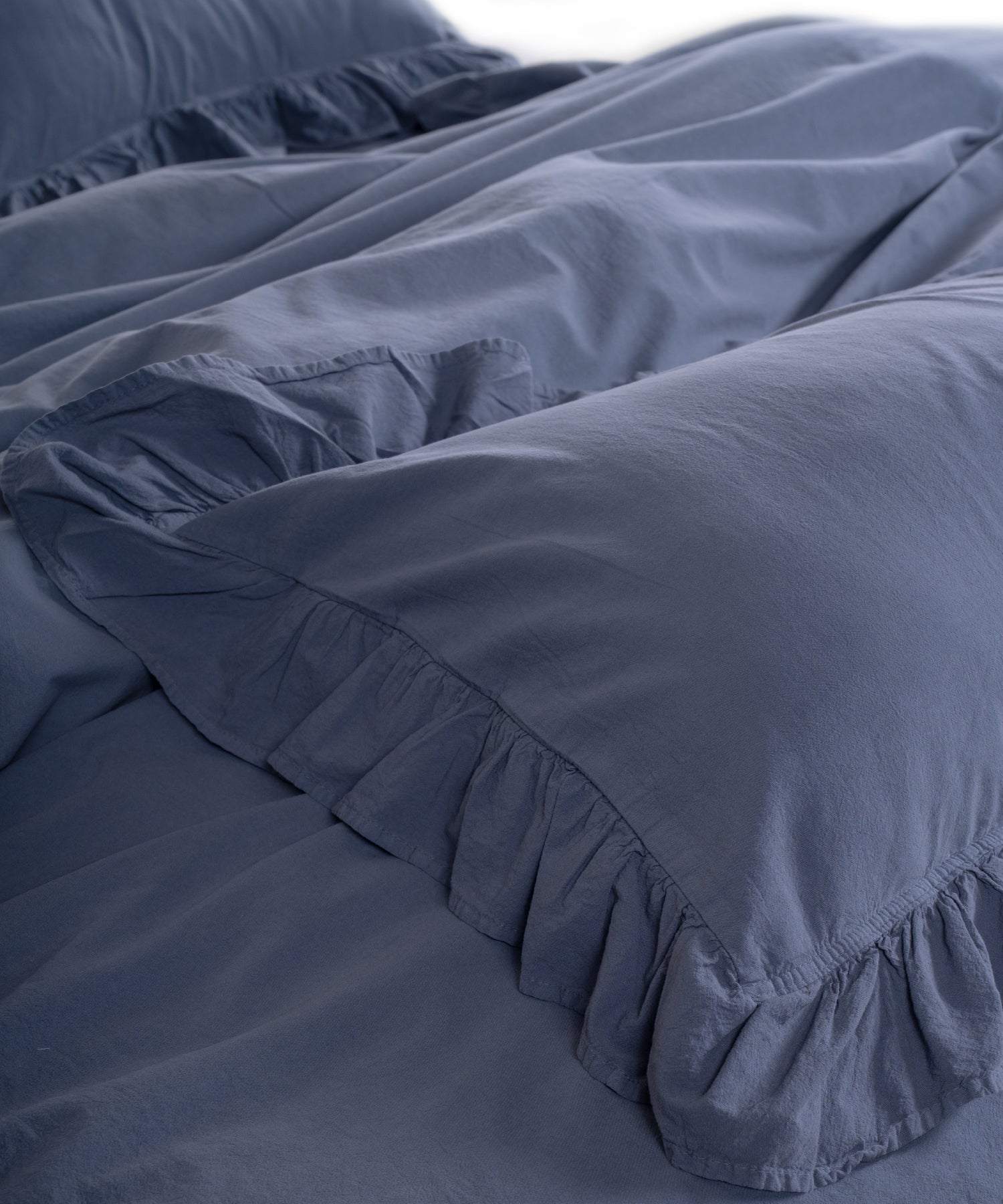 Close-up of ruffled edges on natural grey stonewashed cotton pillowcase with durable double-needle stitching