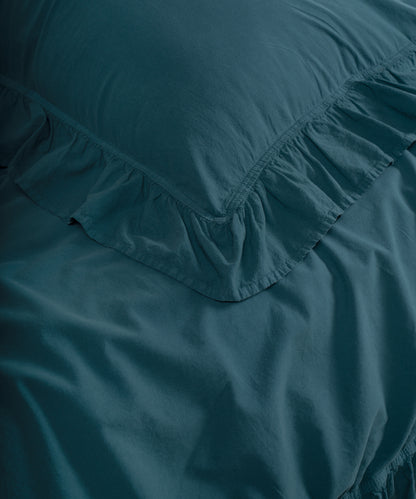 Close-up of ruffled edges on dark green stonewashed cotton pillowcase with double-needle stitching