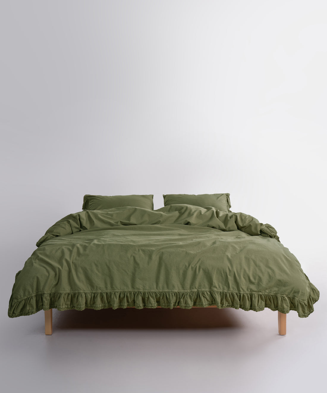Close up of Sicilia Capulet Olive stonewashed cotton duvet cover with elegant ruffle lace trim detail