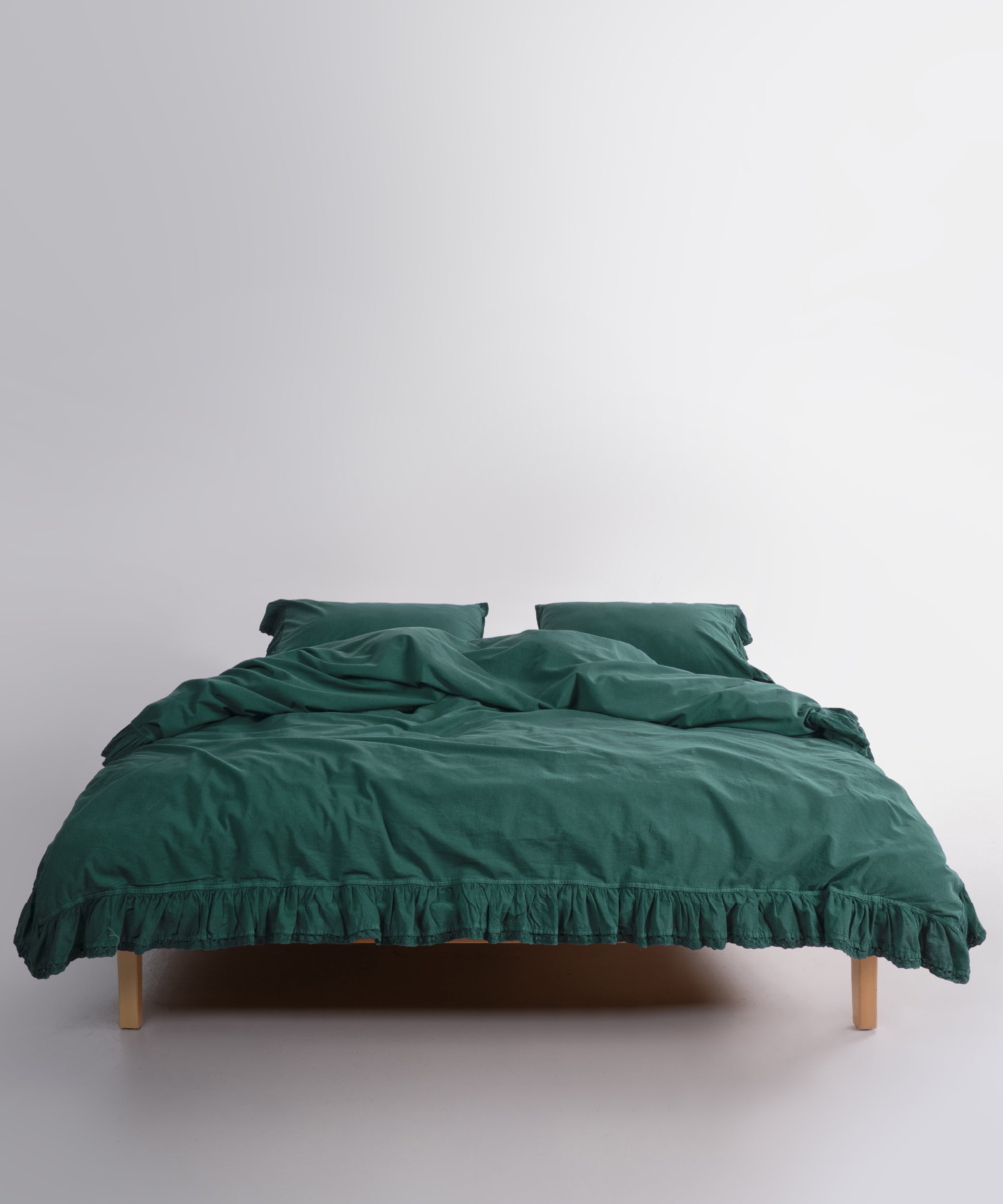 Close up of Sicilia Dark Green stonewashed cotton duvet cover with elegant ruffle lace trim detail