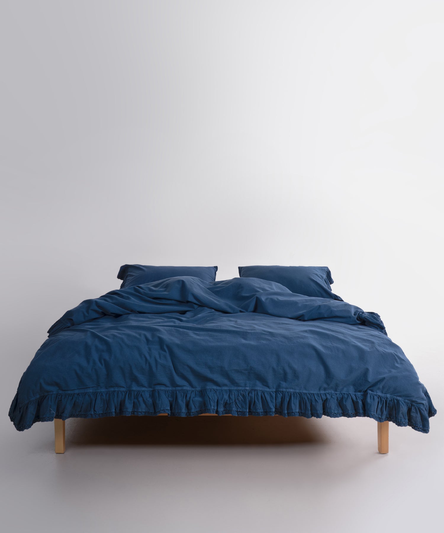 Close up of Sicilia Dress Blue stonewashed cotton duvet cover with elegant ruffle lace trim detail