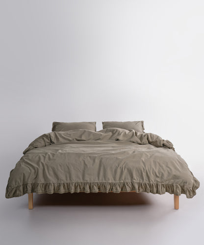 Close up of Sicilia Mediterranean Green stonewashed cotton duvet cover with elegant ruffle lace trim detail