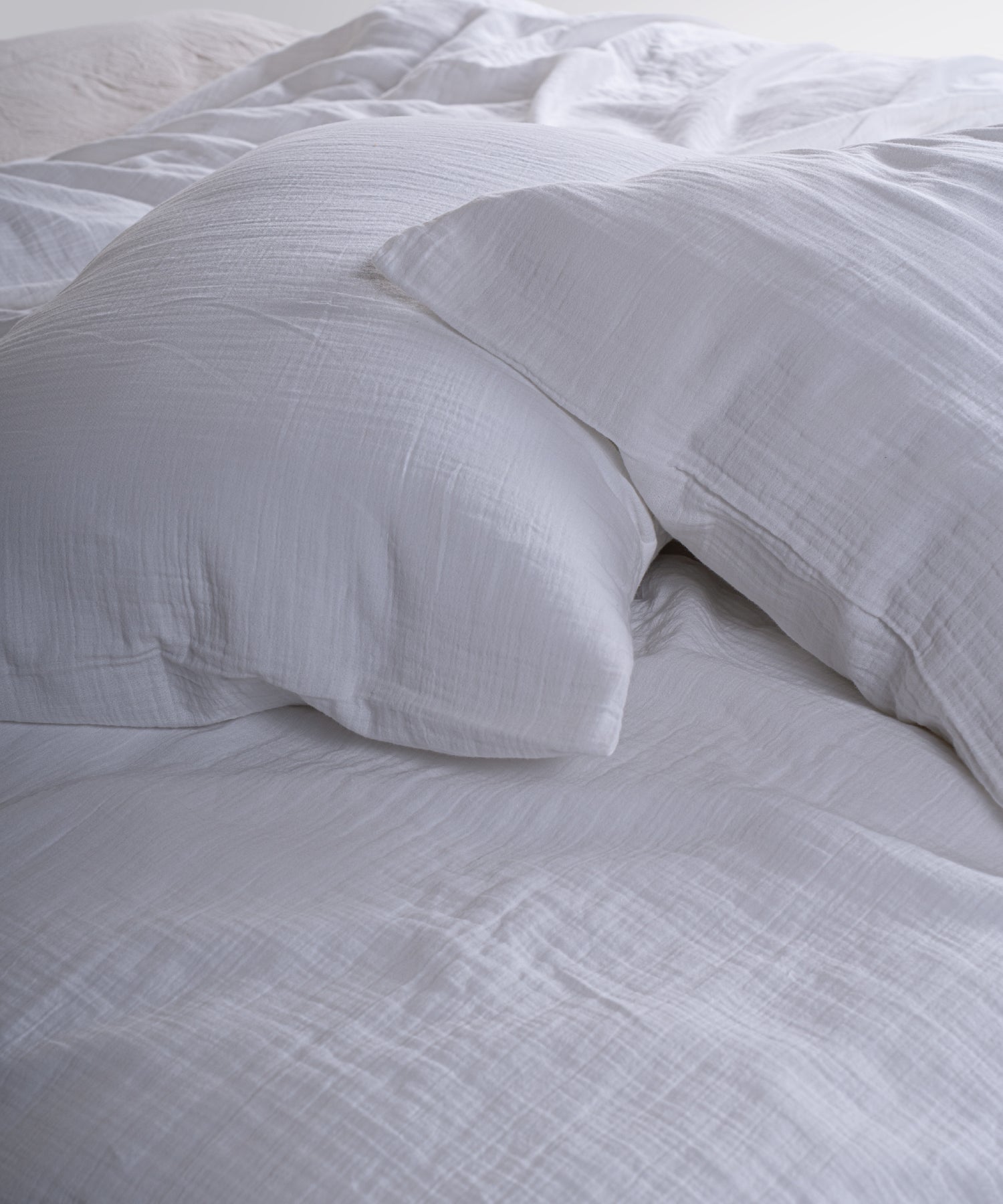 Cloud 100% Cotton Gauze-Muslin Duvet Cover Set Snow White casually tousled on a wooden platform bed – Limasso London