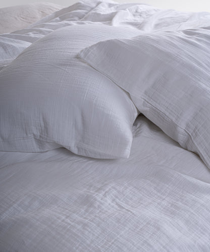 Cloud 100% Cotton Gauze-Muslin Duvet Cover Set Snow White casually tousled on a wooden platform bed – Limasso London