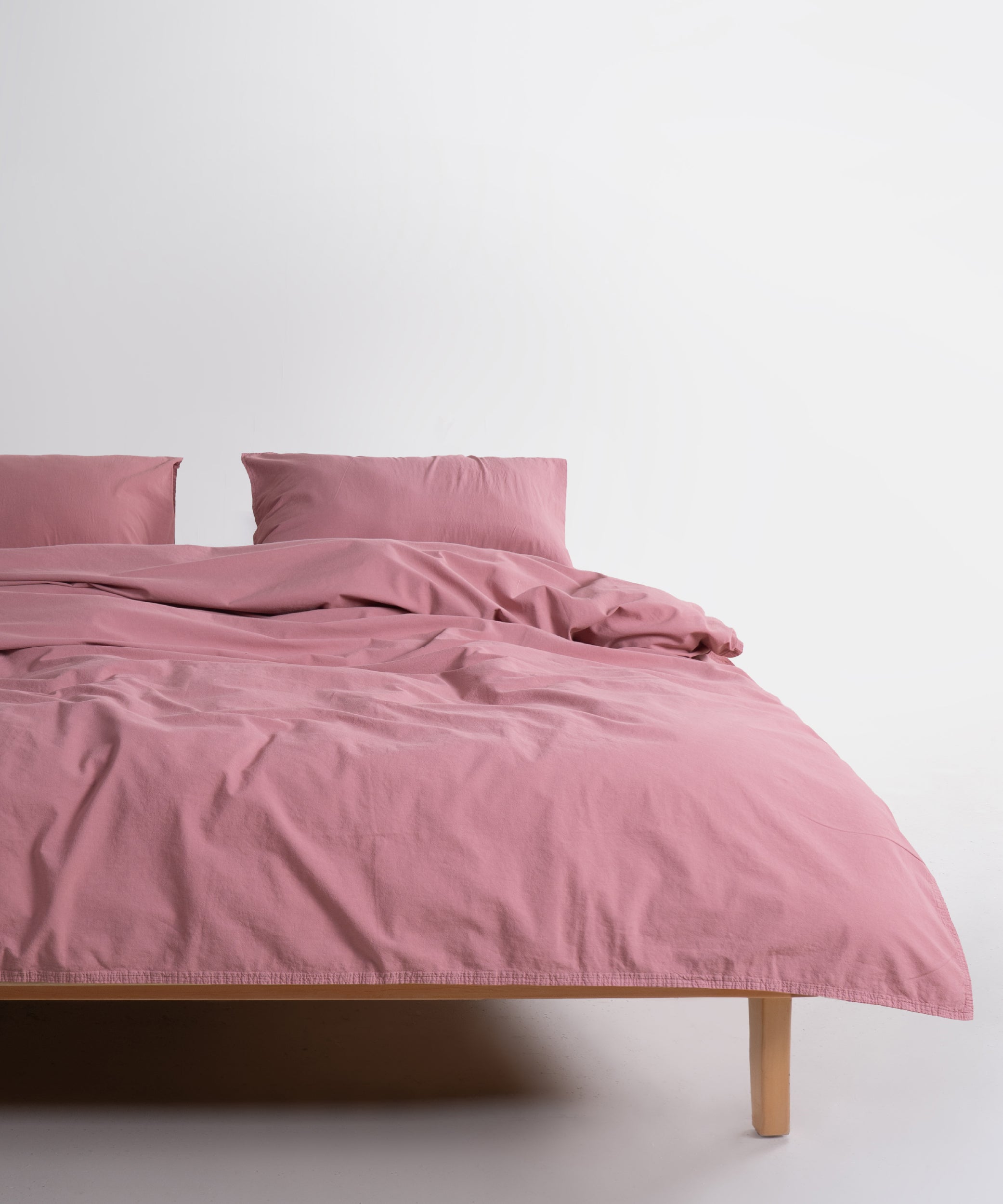 Stonewashed 100% cotton duvet cover set in Old Rose with matching pillowcases styled on bed in modern bedroom