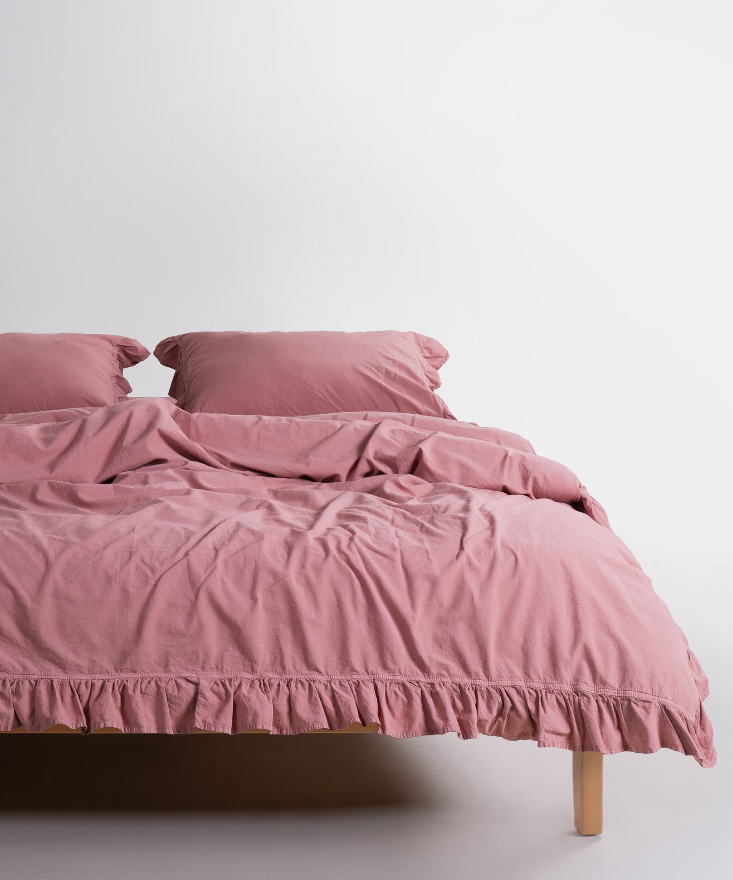 Old Rose stonewashed 100% cotton duvet cover set with ruffle edges and matching pillowcases styled on bed
