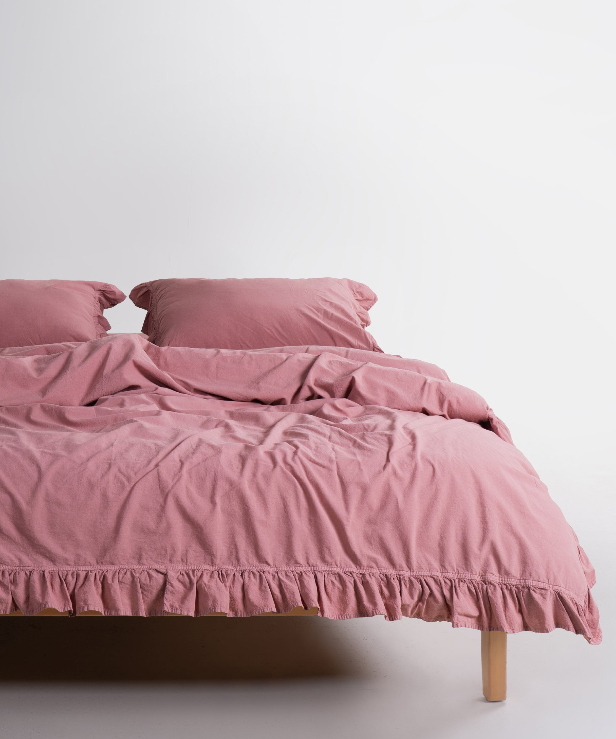 Old Rose stonewashed 100% cotton duvet cover set with ruffle edges and matching pillowcases styled on bed