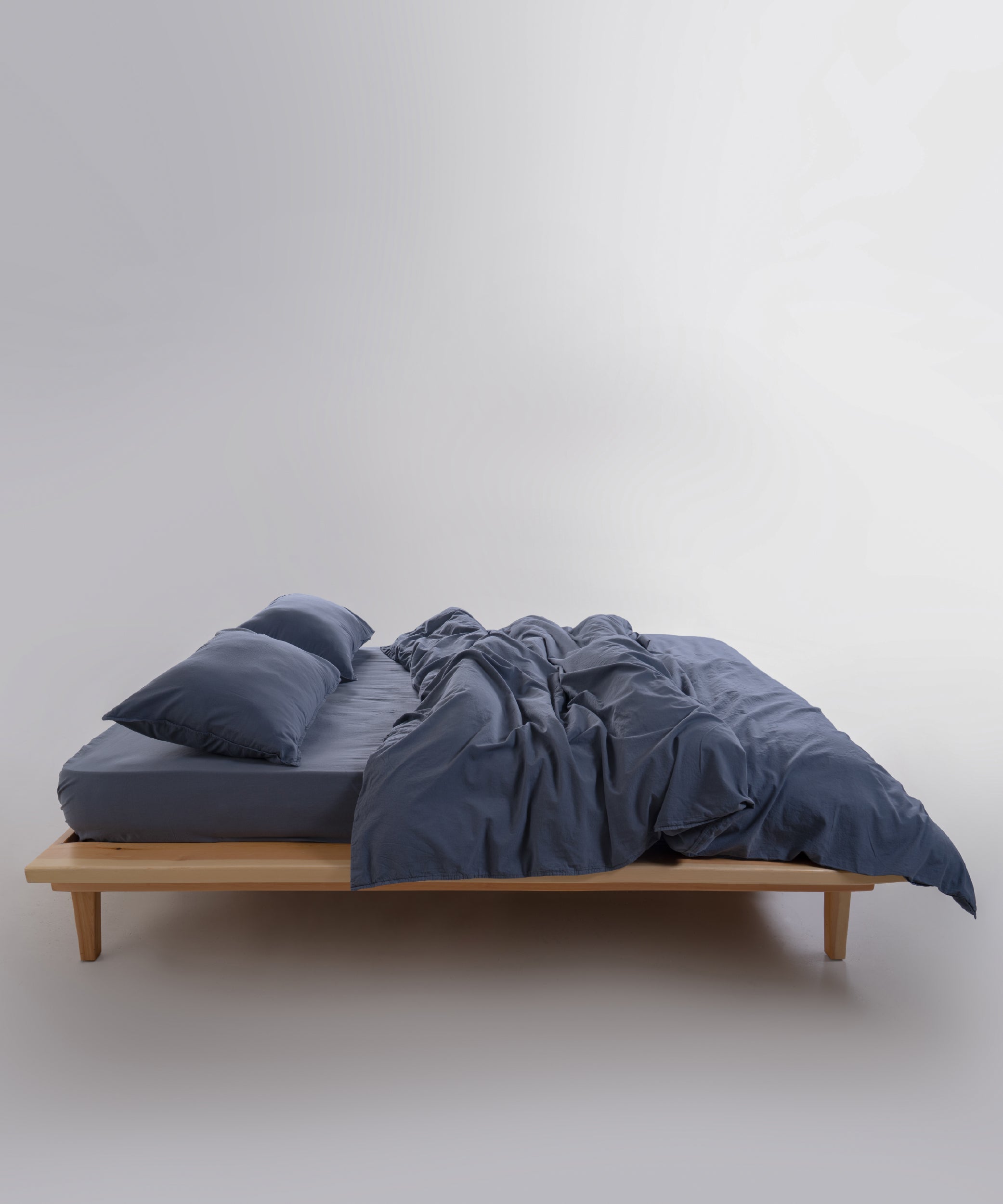 Detail of stonewashed cotton duvet cover in natural grey highlighting quality stitching and relaxed finish