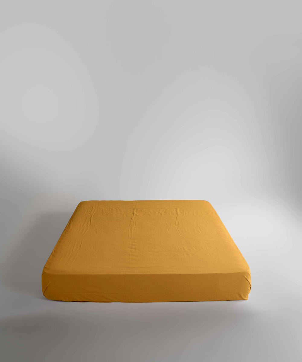 Limasso stonewashed 100% cotton fitted sheet in Mustard, soft breathable mustard yellow bed sheet with elasticated corners, suitable for UK mattresses.