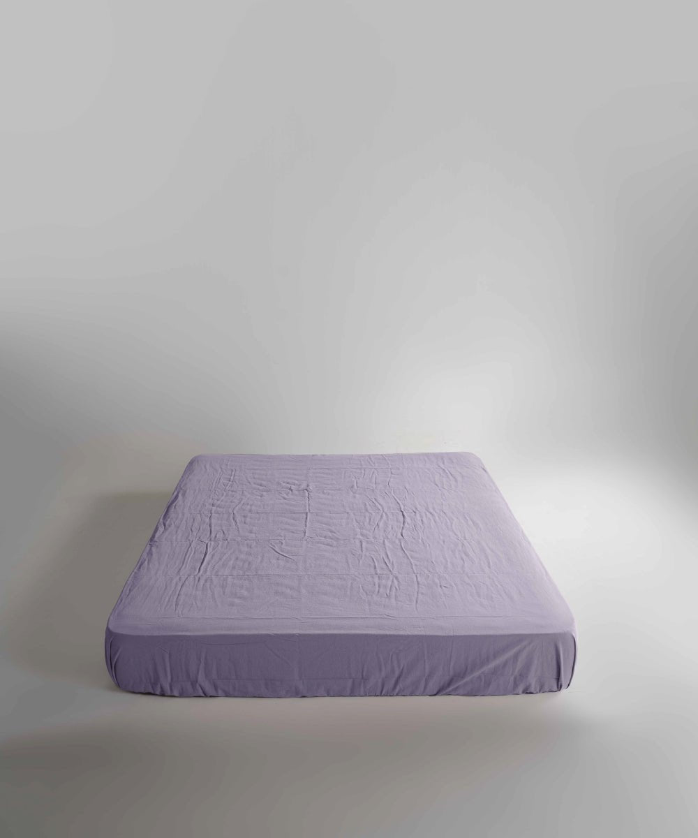 Limasso stonewashed 100% cotton fitted sheet in Violet, soft breathable purple bed sheet with elasticated corners, suitable for UK mattresses.