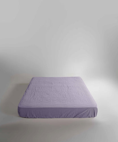 Limasso stonewashed 100% cotton fitted sheet in Violet, soft breathable purple bed sheet with elasticated corners, suitable for UK mattresses.