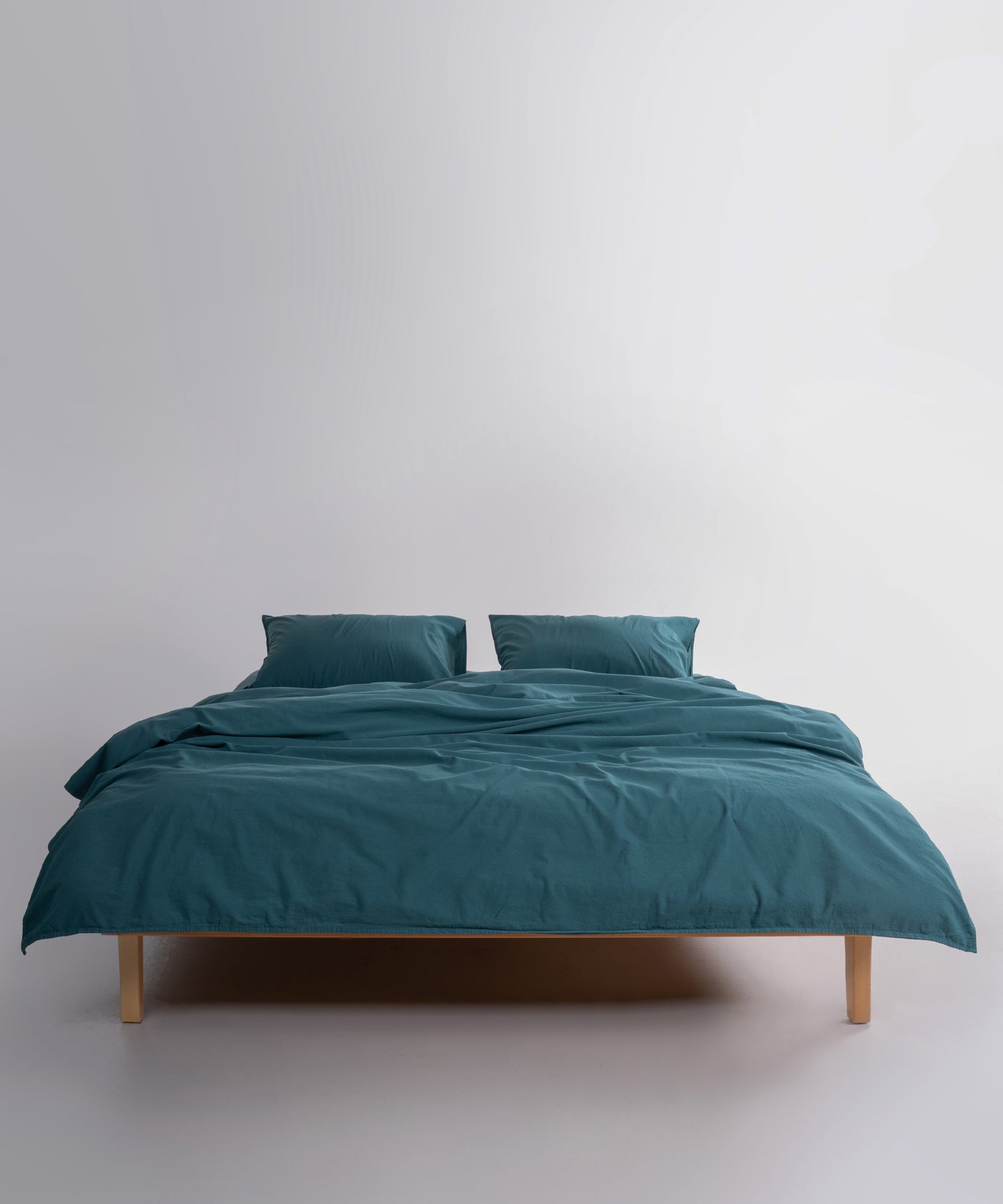 Close-up view of dark green stonewashed cotton duvet cover showing soft, breathable fabric texture