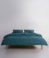 Close-up view of dark green stonewashed cotton duvet cover showing soft, breathable fabric texture