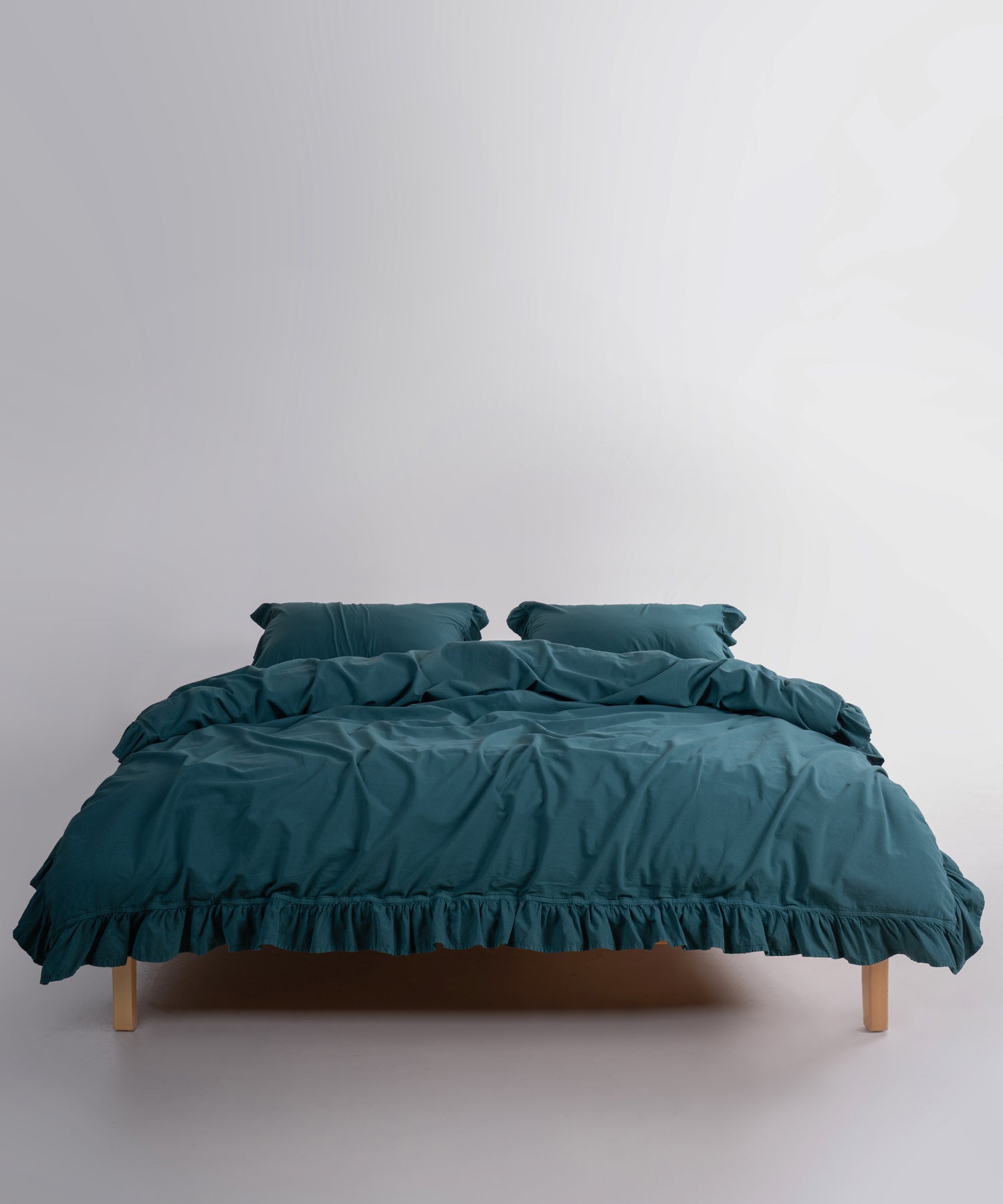 Close-up of stonewashed 100% cotton fabric in dark green, showing soft texture and natural finish