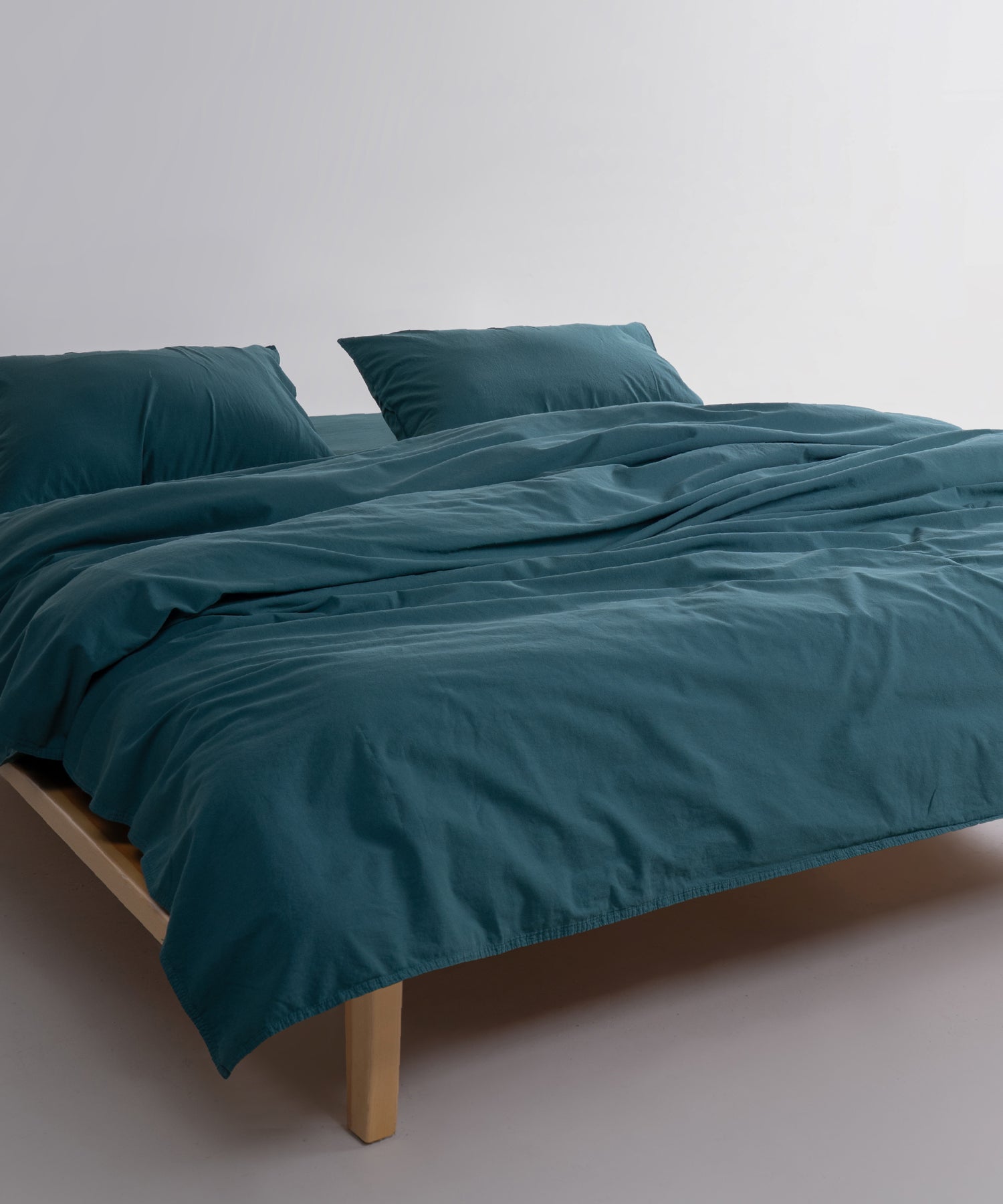 Close-up of stonewashed 100% cotton fabric in dark green showing soft, breathable texture