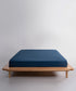 Stonewash 100% soft cotton fitted sheet in dress blue with smooth finish and deep fitted corners for UK USA and Canada mattresses