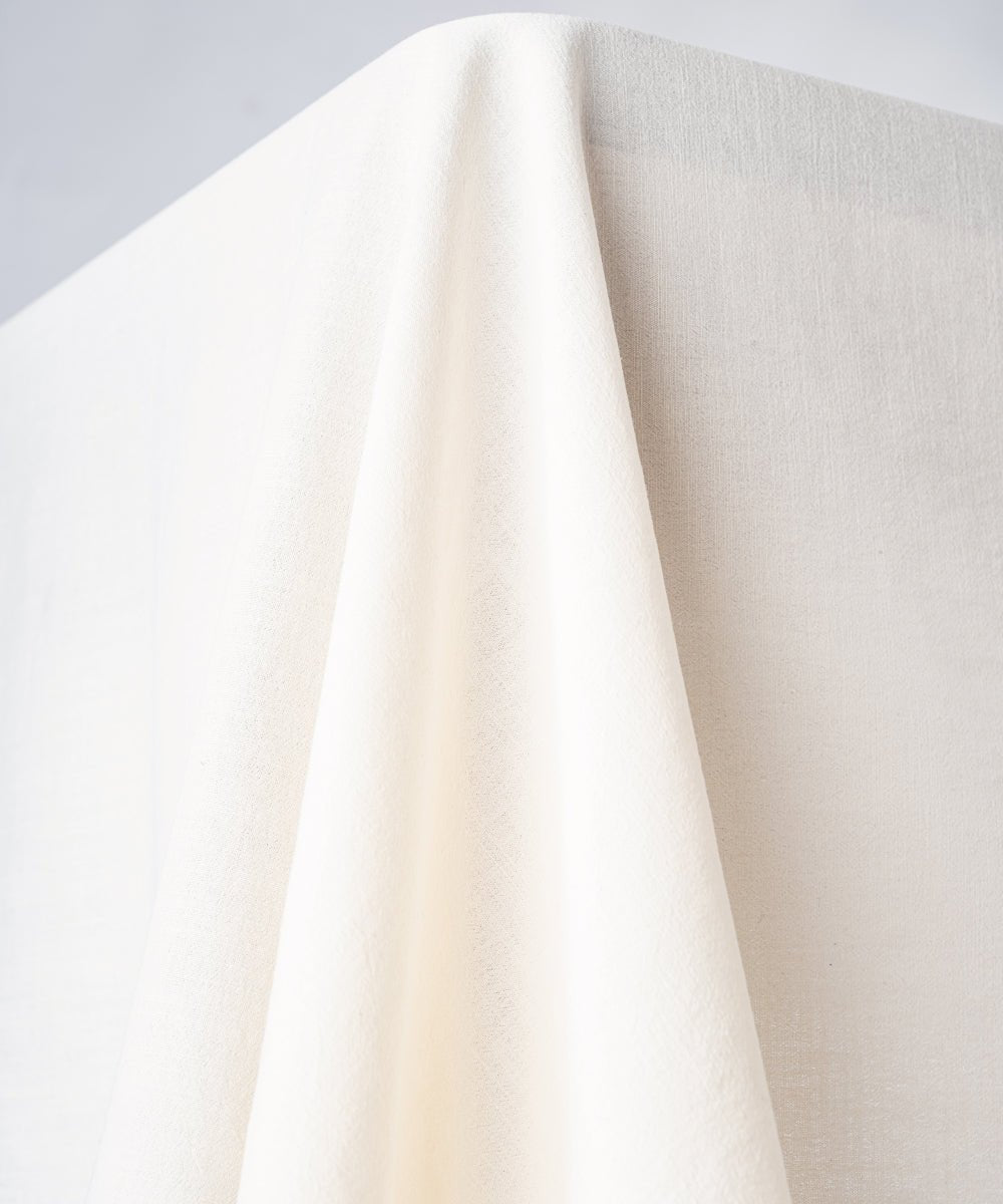 Close up of cream stonewashed cotton tablecloth showing soft texture and embroidered edging detail, premium UK table linen