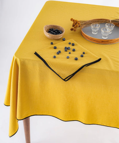 Close up of honey stonewashed cotton tablecloth showing soft texture and embroidered edging detail, premium UK table linen