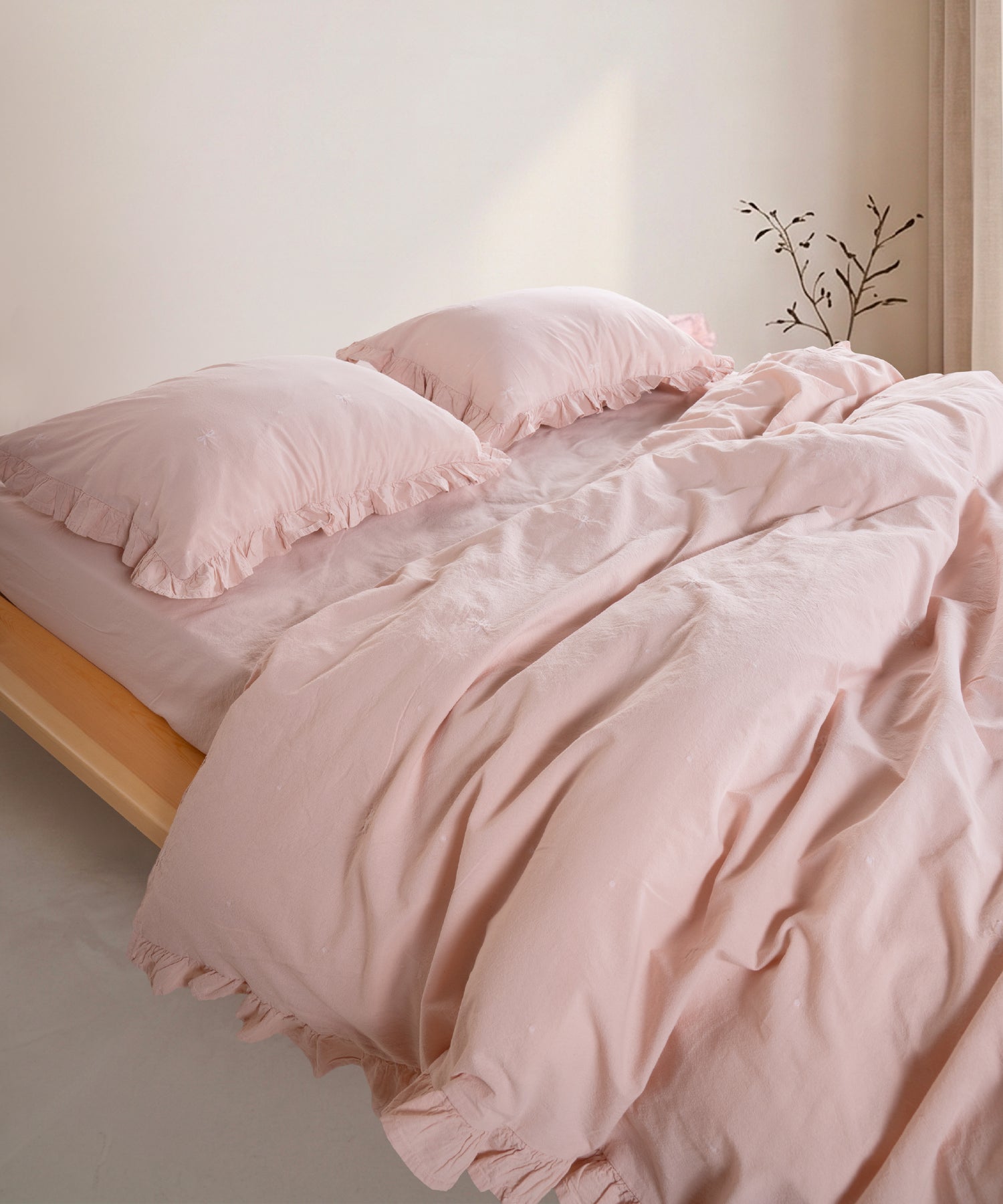 Pristine stonewashed 100% cotton duvet cover set with ruffled edges styled on modern UK bed