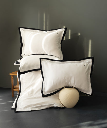 Close-up of white cotton sateen fabric showing smooth silky texture and subtle sheen hotel bedding style