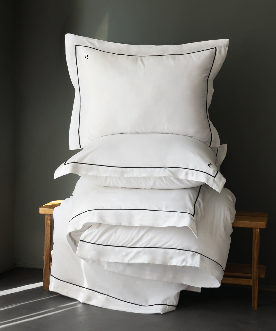 Luxury Cotton Sateen Oxford Duvet Cover Set and pillowcases stacked showing fine black contrast piping detail – Limasso