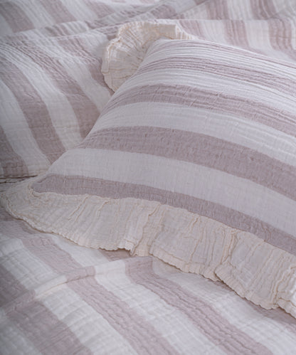 Close-up of yarn dyed 100% cotton muslin fabric with garment washed finish, natural cream base with thick beige stripes