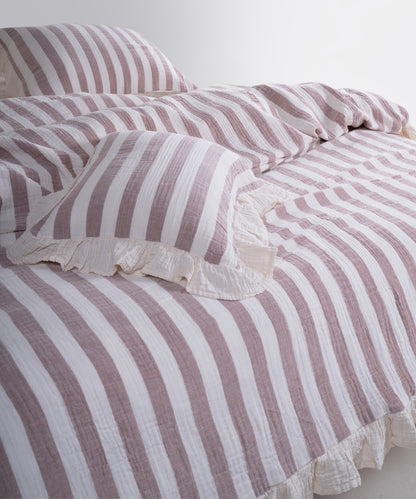 Close-up of yarn dyed 100% cotton muslin fabric with garment washed finish, natural cream base with bold brown stripes