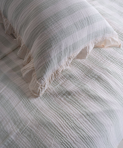 Close-up of yarn dyed 100% cotton muslin fabric with garment washed finish, natural cream base with mint stripes