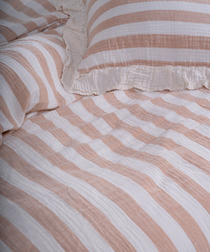Close-up of yarn dyed 100% cotton muslin fabric with garment washed finish, natural cream base with beige and mustard stripes
