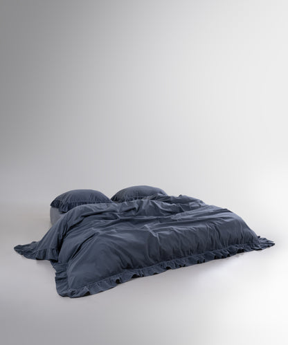 Anthracite stonewashed cotton duvet cover set styled on bed with soft ruffled edges
