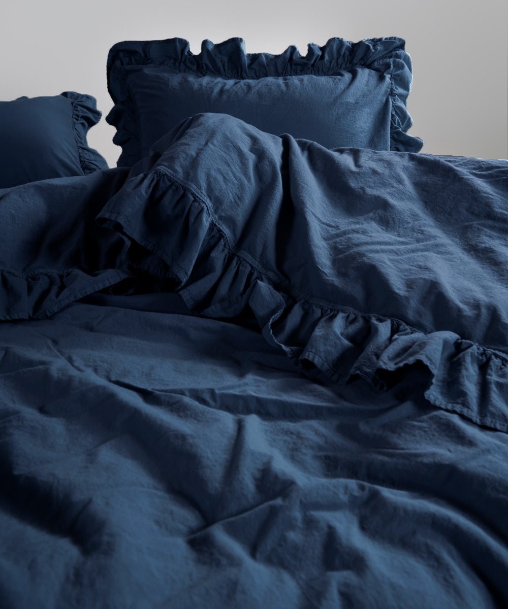 Stonewashed cotton pillowcases in dress blue with soft ruffled edges
