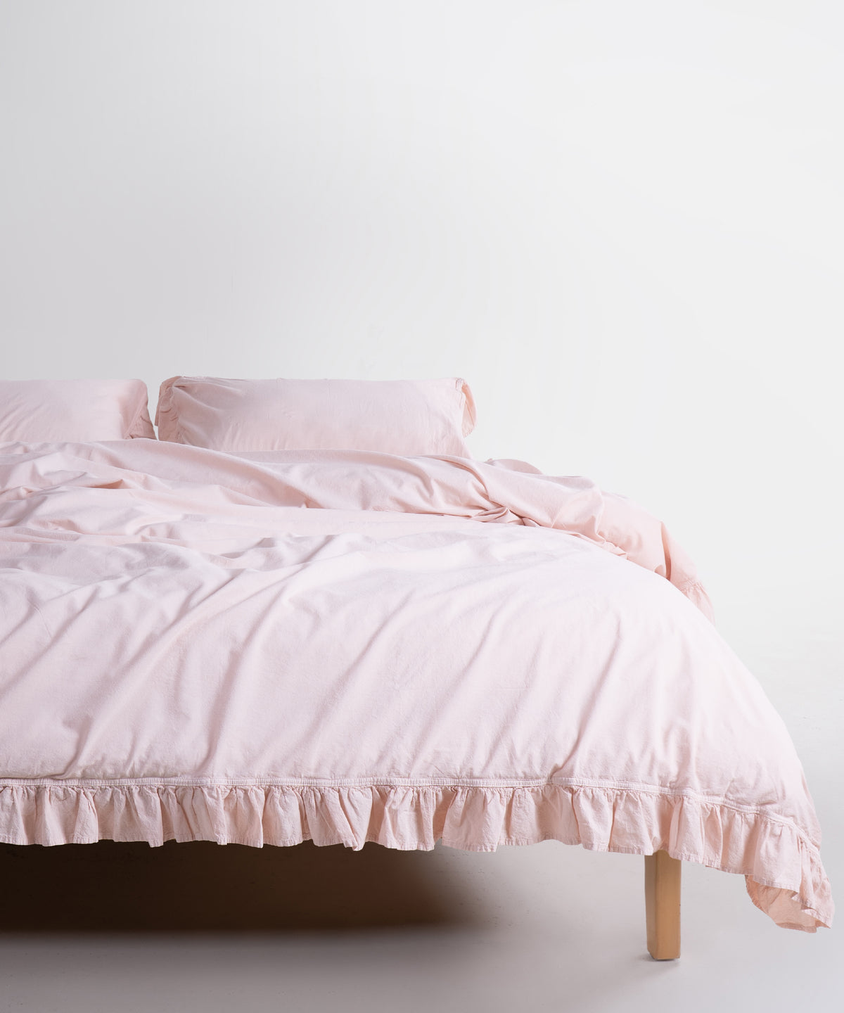 Stonewashed Exclusive Ruffled Duvet Cover Set Pristine on a double bed with matching ruffled pillowcases – Limasso London