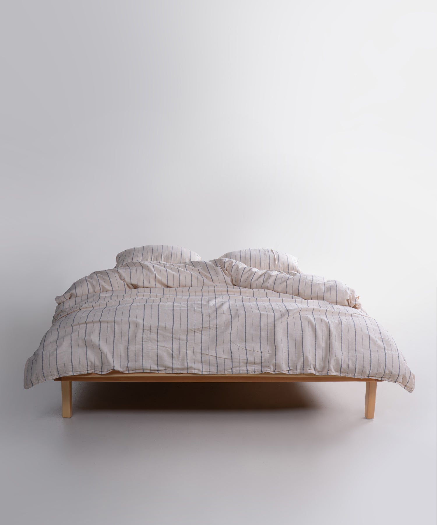 Garment washed 100% cotton duvet cover set in natural cream with navy stripes, soft breathable bedding for UK homes