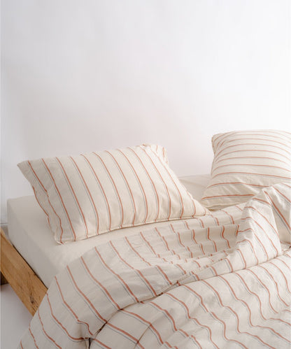 Garment washed 100% cotton duvet cover set in natural cream with red stripes and black speckle details
