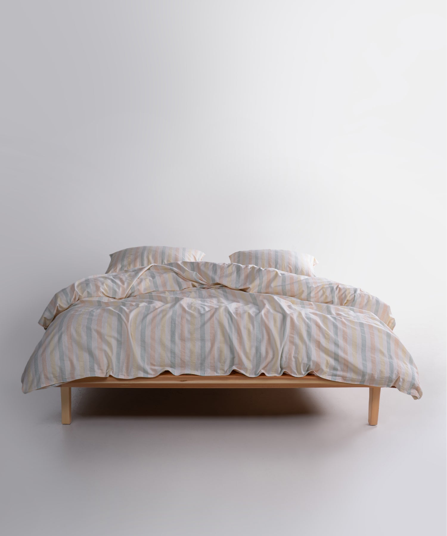 Garment washed 100% cotton duvet cover set in natural cream with soft blue, blush and yellow stripes