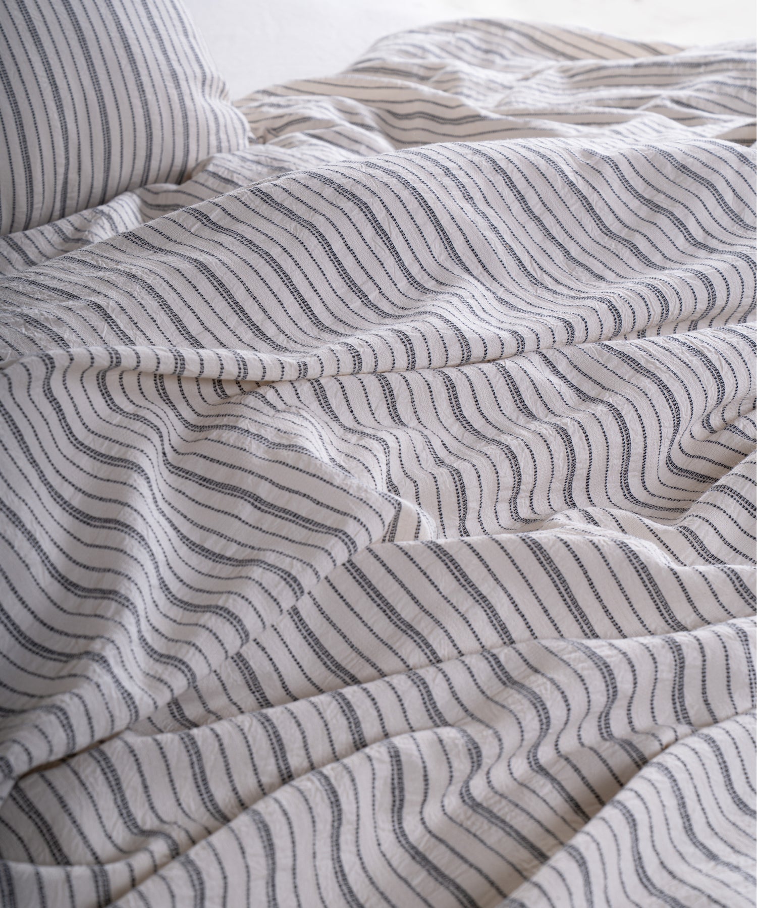 Close-up of garment washed cotton fabric with navy dotted stripe detail
