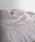 Close-up of garment washed cotton fabric showing natural cream yarn with black speckled texture