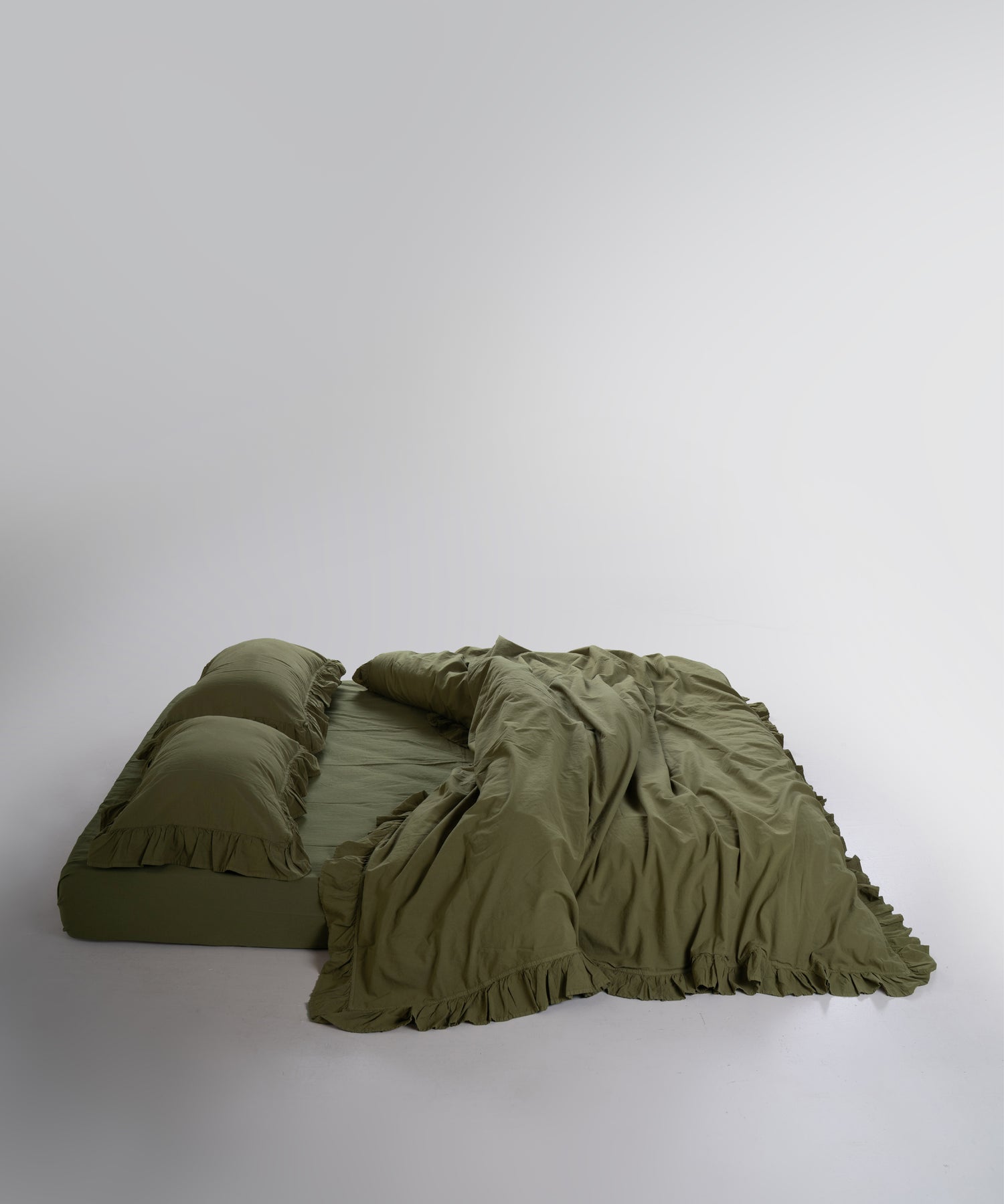Stonewashed 100% cotton duvet cover set in Capulet Olive by Limasso London with ruffle detailing
