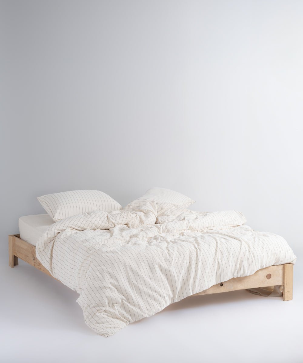 Natural cream cotton duvet cover set with black stripes styled on a bed